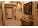 Inviting foyer with a console table, decorative clock, and neutral tile flooring at 14977 W Charter Oak Rd, Surprise, AZ 85379