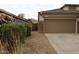 Side view of the house with a two-car garage and desert landscaping at 14977 W Charter Oak Rd, Surprise, AZ 85379
