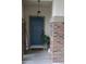 The front door has brick accents, a stylish light fixture, and a potted plant at 14977 W Charter Oak Rd, Surprise, AZ 85379