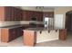 Spacious kitchen with stainless steel appliances, dark wood cabinets, and central island at 14977 W Charter Oak Rd, Surprise, AZ 85379