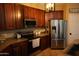 Modern kitchen with stainless steel appliances, dark wood cabinetry, and ample counter space at 14977 W Charter Oak Rd, Surprise, AZ 85379