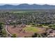 Scenic aerial shot of homes near a baseball park with mountains in the distance, surrounded by lush greenery at 15518 W Ocotillo Ln, Surprise, AZ 85374