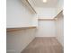 Walk-in closet features neutral carpeting and simple rod shelving at 15518 W Ocotillo Ln, Surprise, AZ 85374