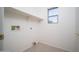 Functional laundry room with tile flooring, utility connections, window, and ample space at 15518 W Ocotillo Ln, Surprise, AZ 85374