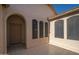 Inviting covered patio area featuring tiled flooring and arched windows, offering outdoor living at 15518 W Ocotillo Ln, Surprise, AZ 85374