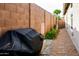 Enclosed backyard featuring a grill, block wall, and desert landscaping at 16551 W Winston Dr, Goodyear, AZ 85338