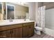 Bathroom featuring double sink vanity, and tub-shower combo with decorative shower curtain at 16551 W Winston Dr, Goodyear, AZ 85338
