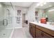 Bathroom with double sink vanity, tiled floors, and walk-in shower with glass doors at 16551 W Winston Dr, Goodyear, AZ 85338