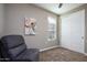 Neutral bedroom featuring a comfortable chair, floral art, and closet with sliding doors at 16551 W Winston Dr, Goodyear, AZ 85338