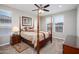 Bedroom with a four poster bed, ceiling fan and two windows with window coverings at 16551 W Winston Dr, Goodyear, AZ 85338
