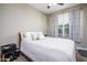Bedroom with a full-sized bed, ceiling fan, window with blinds, and minimal furnishings at 16551 W Winston Dr, Goodyear, AZ 85338