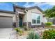 Charming single-story home featuring stone accents, a well-manicured garden, and an inviting entryway at 16551 W Winston Dr, Goodyear, AZ 85338
