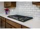 Close-up of a modern gas cooktop and range set against white subway tile backsplash in a gourmet kitchen at 16551 W Winston Dr, Goodyear, AZ 85338