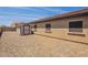 Backyard featuring gravel, a shed, and exterior windows, offering functionality and potential for customization at 17531 W Fetlock Trl, Surprise, AZ 85387