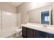 Bathroom features a shower-tub combo and vanity with dark wood cabinetry at 17531 W Fetlock Trl, Surprise, AZ 85387