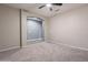 Spacious bedroom featuring neutral carpet, ceiling fan, archway, and ample space at 17531 W Fetlock Trl, Surprise, AZ 85387