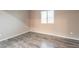Bedroom showcasing gray wood-look floors, natural light from a window, and neutral paint at 17531 W Fetlock Trl, Surprise, AZ 85387