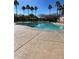 Large community pool with ample seating, tall palm trees and a well-maintained pool deck at 17531 W Fetlock Trl, Surprise, AZ 85387