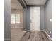 Inviting foyer with wood-look tile flooring, neutral paint, and a view into the living area at 17531 W Fetlock Trl, Surprise, AZ 85387