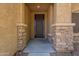 Close-up of the front entrance showcasing stone pillars and a modern screen door at 17531 W Fetlock Trl, Surprise, AZ 85387