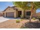 Lovely home featuring a spacious three-car garage and inviting desert landscaping, including a beautiful tree at 17531 W Fetlock Trl, Surprise, AZ 85387