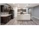 A kitchen boasting dark wood cabinetry, an island with a sink, and modern stainless-steel appliances at 17531 W Fetlock Trl, Surprise, AZ 85387