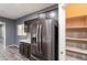 Modern kitchen featuring stainless steel refrigerator and spacious pantry for optimal storage at 17531 W Fetlock Trl, Surprise, AZ 85387