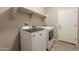 Laundry room featuring a washer, dryer, and overhead shelving at 17531 W Fetlock Trl, Surprise, AZ 85387