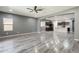 Open-concept living room that connects to the kitchen featuring gray walls and wood-style flooring at 17531 W Fetlock Trl, Surprise, AZ 85387