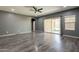 Open-concept living room with wood flooring, a ceiling fan, and sliding glass door to the outdoor space at 17531 W Fetlock Trl, Surprise, AZ 85387