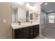 Bathroom showcasing a double sink vanity with granite counters and access to a large shower at 17531 W Fetlock Trl, Surprise, AZ 85387