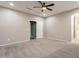 Spacious main bedroom featuring carpet floors, a ceiling fan, neutral paint, and an en-suite bathroom entrance at 17531 W Fetlock Trl, Surprise, AZ 85387