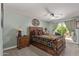 Charming bedroom showcasing a wooden bed frame, side table, ceiling fan, and backyard access at 18626 N 130Th Ave, Sun City West, AZ 85375