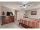Cozy bedroom featuring a ceiling fan, dresser, and a comfortable bed with colorful patterned bedding at 18626 N 130Th Ave, Sun City West, AZ 85375
