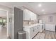 Well-organized laundry room with gray and white cabinets, modern appliances, and a convenient utility sink at 18626 N 130Th Ave, Sun City West, AZ 85375