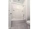 Bright bathroom featuring a tile-surround bathtub and shower combination at 19954 W Moonlight Path, Buckeye, AZ 85326