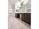 Elegant bathroom featuring double vanity, a large mirror, and tiled floors at 19954 W Moonlight Path, Buckeye, AZ 85326