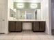 A luxurious bathroom featuring a double vanity, large mirror, and tiled flooring at 19954 W Moonlight Path, Buckeye, AZ 85326
