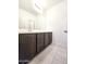 Bathroom vanity featuring dark cabinetry and a large mirror with ample counter space at 19954 W Moonlight Path, Buckeye, AZ 85326