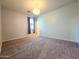 Cozy carpeted bedroom with soft natural light from a side window and a hanging light fixture at 19954 W Moonlight Path, Buckeye, AZ 85326