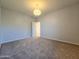 Spacious bedroom with neutral paint and carpet, featuring a modern light fixture at 19954 W Moonlight Path, Buckeye, AZ 85326