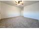 Large carpeted bedroom with a ceiling fan, neutral walls, and natural light at 19954 W Moonlight Path, Buckeye, AZ 85326