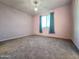 Cozy bedroom with soft pink walls, a window with curtains, and plush carpeting at 19954 W Moonlight Path, Buckeye, AZ 85326