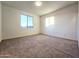 Sunlit bedroom with a large window, neutral carpet, and crisp white walls at 19954 W Moonlight Path, Buckeye, AZ 85326