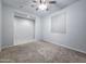 A bedroom featuring carpeted floors and a ceiling fan, next to a tiled room at 19954 W Moonlight Path, Buckeye, AZ 85326