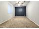 Carpeted bedroom with a modern dark accent wall and a ceiling fan at 19954 W Moonlight Path, Buckeye, AZ 85326