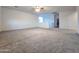 Vast carpeted bonus room with neutral walls, ceiling fan and staircase to lower level at 19954 W Moonlight Path, Buckeye, AZ 85326