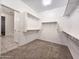 Well-organized walk-in closet with built-in shelving and carpeted floor, ready for storage at 19954 W Moonlight Path, Buckeye, AZ 85326