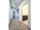 View of carpeted hallway with half bath, featuring tile flooring and dark wood vanity at 19954 W Moonlight Path, Buckeye, AZ 85326