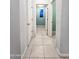 Tile floor hallway featuring access to several rooms and a window view at 19954 W Moonlight Path, Buckeye, AZ 85326